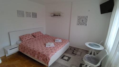 - une chambre avec un lit, une table et une chaise dans l'établissement Poesia Apartment, à Novi Sad