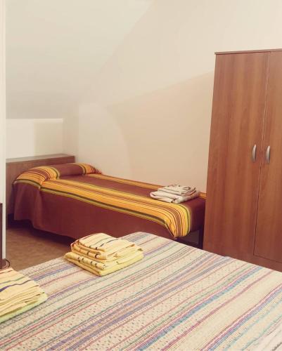 two beds in a hotel room with towels on them at B&B La Villetta in San Benedetto del Tronto