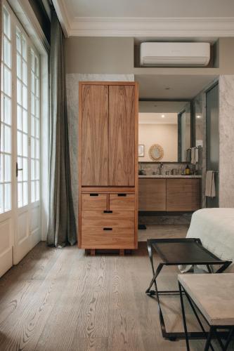 a bedroom with a large wooden cabinet and a living room at Nima Local House Hotel & Spa in Mexico City