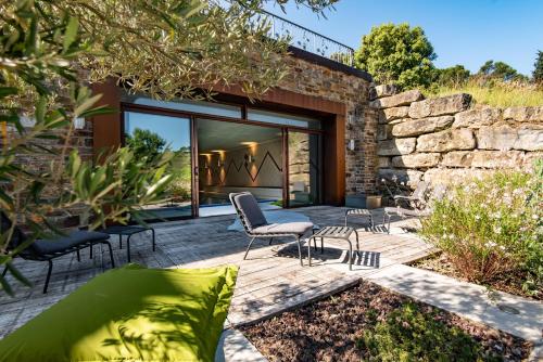 a patio with chairs and a stone wall at Domaine Calmel & Joseph in Montirat