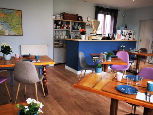 パンポルにあるChambres d'hôtes "Le Clos de la Baie"の木製テーブルと紫色の椅子が備わるレストラン