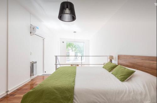 1 dormitorio blanco con 1 cama grande con sábanas verdes en Fantástico duplex tipo loft en Recoleta en Buenos Aires