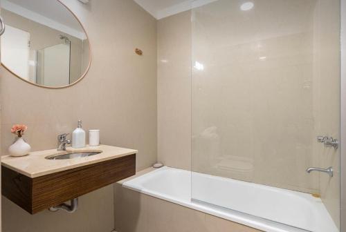 y baño con lavabo y ducha con espejo. en Fantástico duplex tipo loft en Recoleta en Buenos Aires