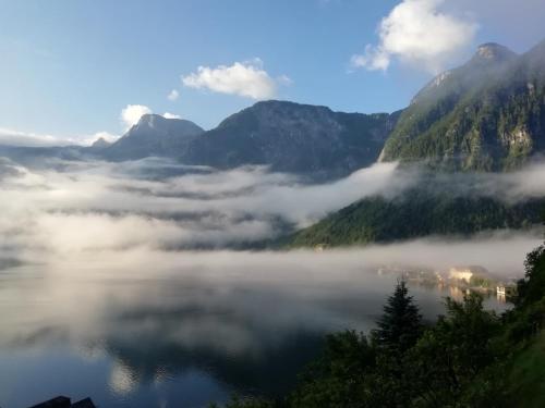 a view of a valley of fog in the mountains at Apartment Müllerstiege in Hallstatt