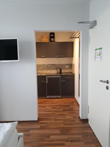 a kitchen with black cabinets and a wooden floor at Haus Achtern Diek in erster Reihe am Meer in Fehmarn