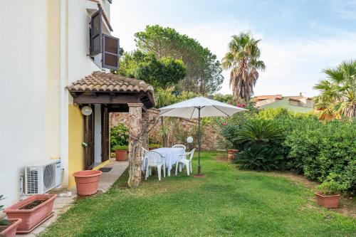 a patio with a table and an umbrella at Appartamento Chia C in Chia