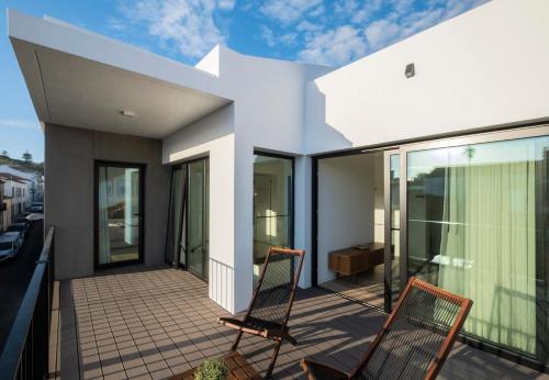 a house with two chairs on a balcony at Magma Hostel in Ponta Delgada