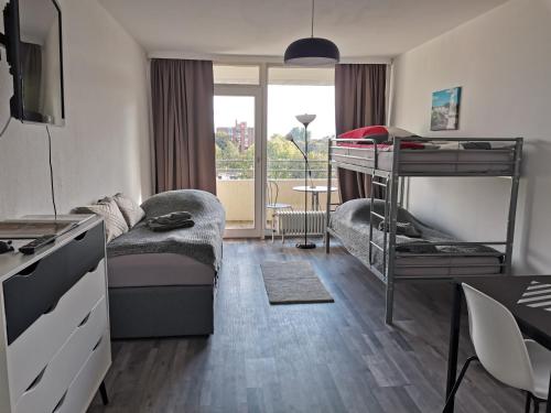 ハノーファーにある1-Zimmer Appartement in Hannover/Bemerodeのベッドルーム1室(二段ベッド1組、デスク、ベッド1台付)