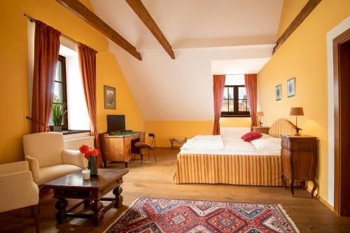 Rosenburg的住宿－Schlossgasthof & Hotel Rosenburg，一间卧室配有一张床、一张沙发和一张桌子