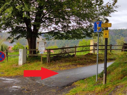 a sign with a red arrow on a road at Mezná 85 in Hřensko