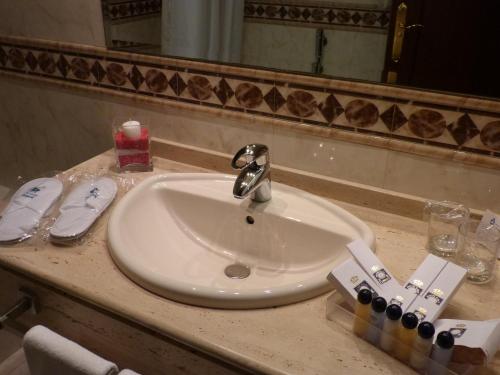 a white sink in a bathroom with a mirror at Hotel Golf Campoamor in Dehesa de Campoamor