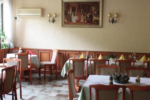 a restaurant with tables and chairs and a painting on the wall at Landgasthof Wiesenmühle in Burg Hohenstein