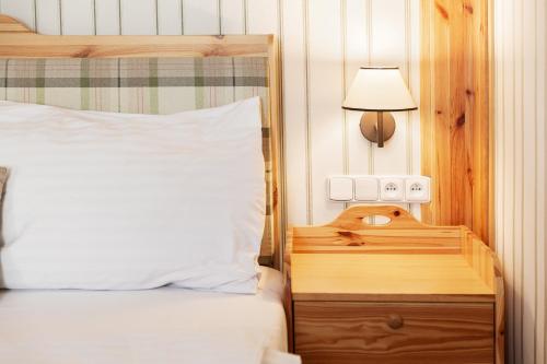 a bedroom with a bed and a night stand with a lamp at Skalní Mlýn Adršpach in Adršpach