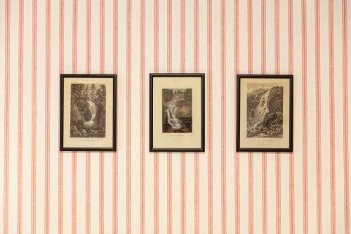 a wall with four framed pictures on a wall at Skalní Mlýn Adršpach in Adršpach