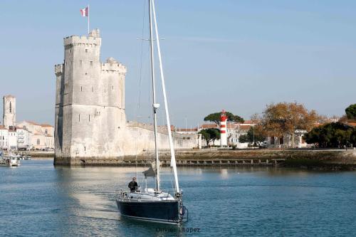 a sailboat in the water in front of a castle at VOILIER ESTEREL in La Rochelle