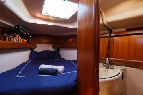 Cette petite chambre comprend un lit et un lavabo. dans l'établissement VOILIER ESTEREL, à La Rochelle