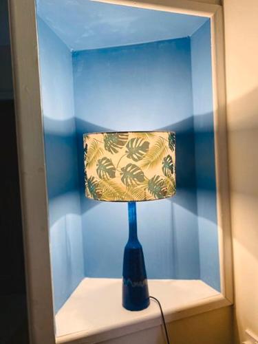 a blue lamp sitting on a shelf in a mirror at Vinegar Hill Pottery in Lymington
