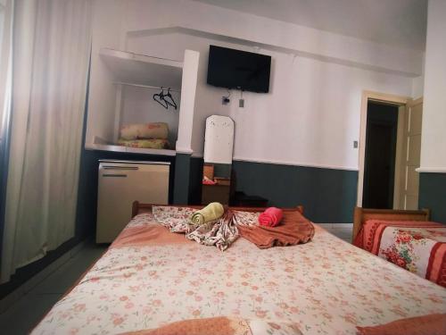 1 dormitorio con 1 cama grande y TV en la pared en Palace Hotel, en Curitiba
