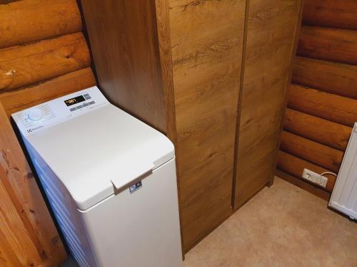 a small white refrigerator in a room with wooden walls at Akureyri Log Cabin in Akureyri