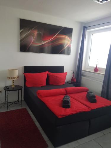 sypialnia z czarnym łóżkiem z czerwonymi poduszkami w obiekcie Romantiksuite only two w mieście Sarstedt