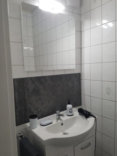 W białej łazience znajduje się umywalka i lustro. w obiekcie Romantiksuite only two w mieście Sarstedt