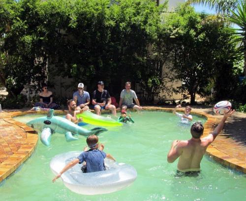 a group of people playing in a swimming pool at 16 Rhodes-North Self Catering Apartment & Studio in Stellenbosch
