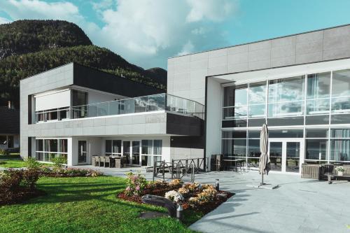 un grand bâtiment avec une terrasse et une cour herbeuse dans l'établissement Hardanger House, à Jondal