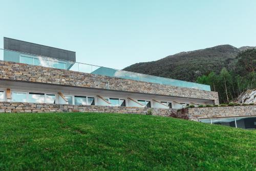 un bâtiment au sommet d'une colline herbeuse à côté d'un bâtiment dans l'établissement Hardanger House, à Jondal