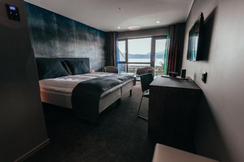 Hardanger House في يوندال: غرفه فندقيه بسرير ونافذه