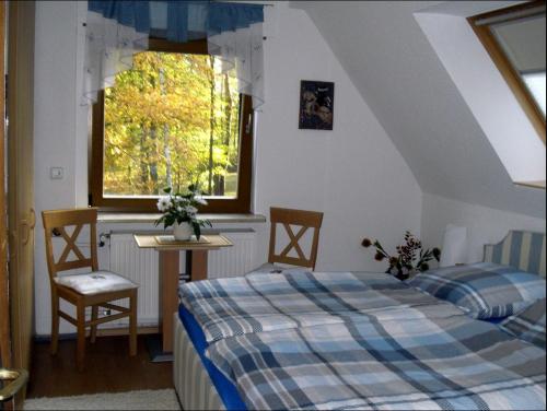um quarto com uma cama, uma mesa e uma janela em Ferienwohnung am Wasserturm em Hohen Neuendorf
