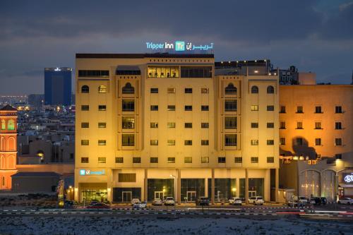a building with a sign on the top of it at Tripper Inn Hotel in Dammam