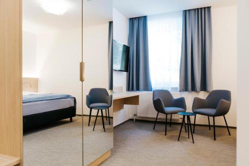 a hotel room with a bed and a desk and chairs at Sankt Magdalena in Linz