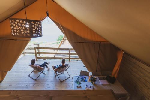 two people sitting in chairs in a tent at BEST LEDRO CAMPING in Ledro