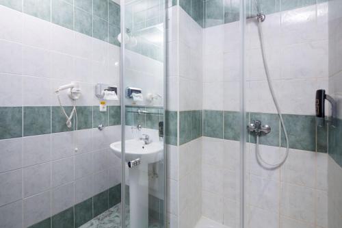 a bathroom with a shower and a sink at Hotel Kultúra in Ružomberok