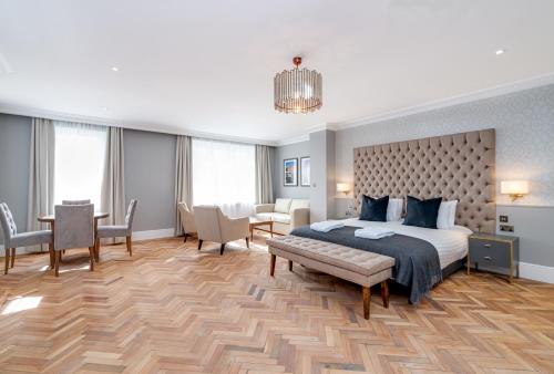 a bedroom with a bed and a table and chairs at Easthampstead Park in Bracknell