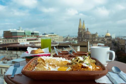 a table with a plate of food and a cup of coffee at Hotel Fenix in Guadalajara