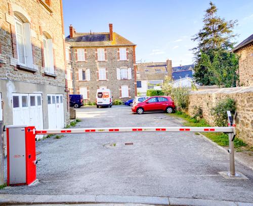a red car is parked in a parking lot at APT bord de Mer, hypercentre Dinard, Parking prive in Dinard