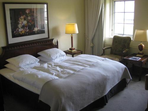 a bedroom with a large bed and a chair at Munkebo Kro & Hotel in Munkebo