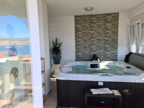 a bath tub in a bathroom with a brick wall at Luxury Apartments Silva with sea view in Trogir