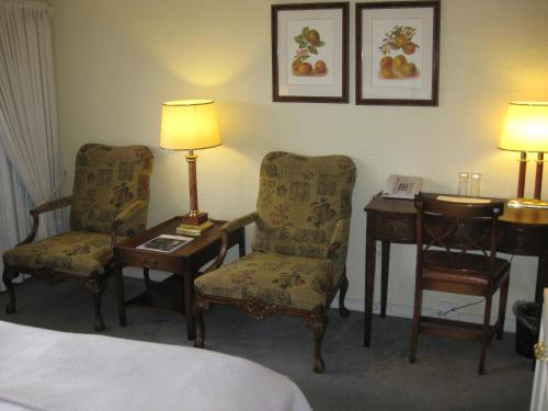 a hotel room with a bed and two chairs and a desk at Munkebo Kro & Hotel in Munkebo