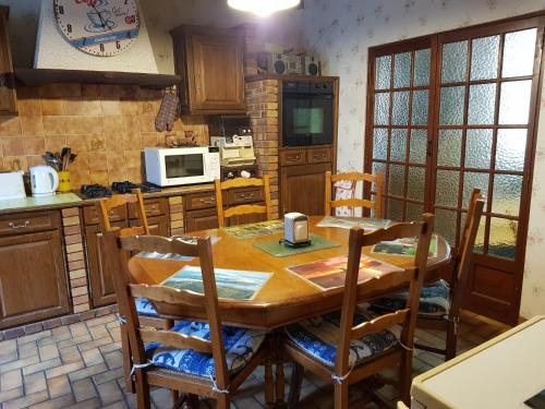 - une cuisine avec une table et des chaises en bois dans l'établissement Au Grand Sapin Chambres chez l'habitant, à Hénonville