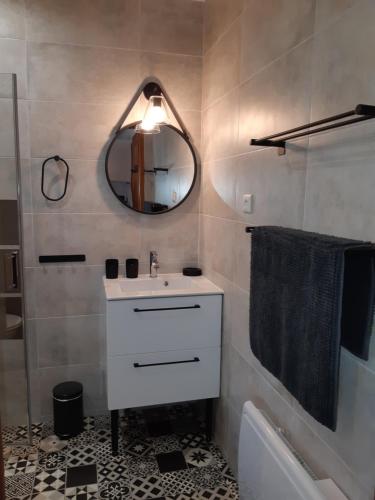 La salle de bains est pourvue d'un lavabo, d'un miroir et d'une baignoire. dans l'établissement Le Mas Mérindol Gîte Ventoux, à Loriol-du-Comtat