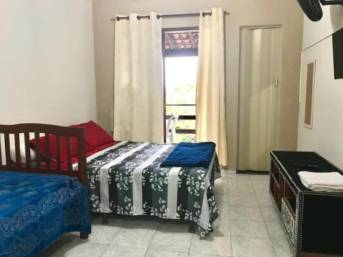 a bedroom with two beds and a window at Pousada Recanto do Mar in Saquarema