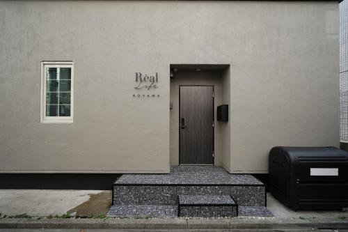 a building with a door and a briefcase in front of it at Real Life AOYAMA in Tokyo