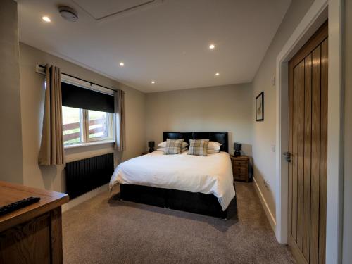 a bedroom with a large bed and a window at Craigard Chalet in Portree