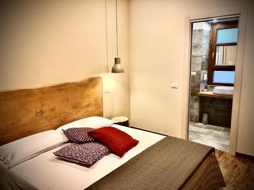een slaapkamer met een bed met 2 kussens erop bij B&B Il Vicolo in Caprarola