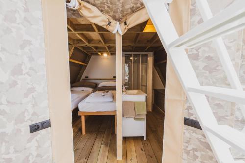 a small room with a bed and a staircase at BEST LEDRO CAMPING in Ledro