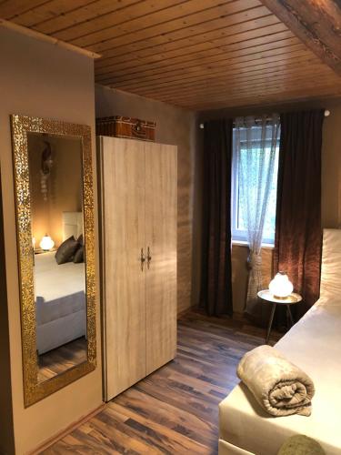 Cette chambre comprend 2 lits et un grand miroir. dans l'établissement Pension Ba-Bett's, à Markt Erlbach