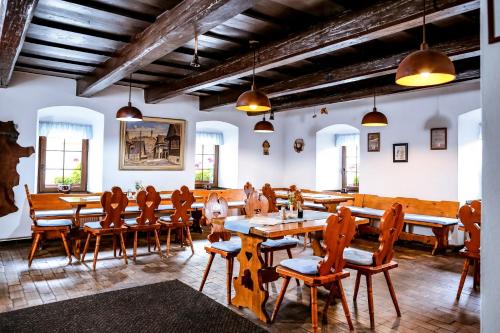 a dining room with wooden tables and chairs at Hotel Gong in Štramberk
