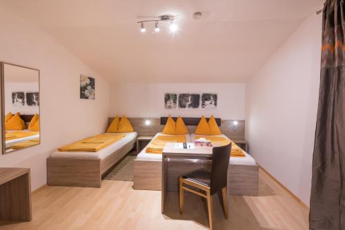 Zimmer mit 2 Betten, einem Tisch und einem Spiegel in der Unterkunft Gästehaus Zwischenberger in Obervellach